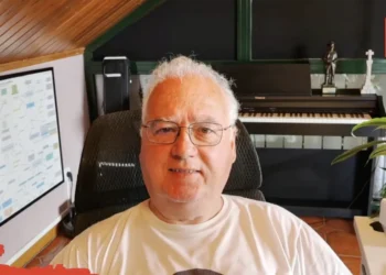 Smiling man with glasses sits in a home studio, a piano and plants behind him, EXPO MÚSICA logo in the top-right corner.