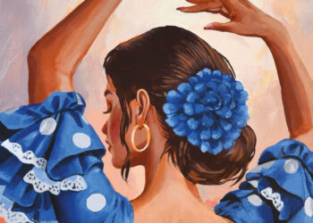 Back view of a dancer with a large blue flower in her hair, wearing a blue polka-dot dress with white lace trim and gold hoop earring.